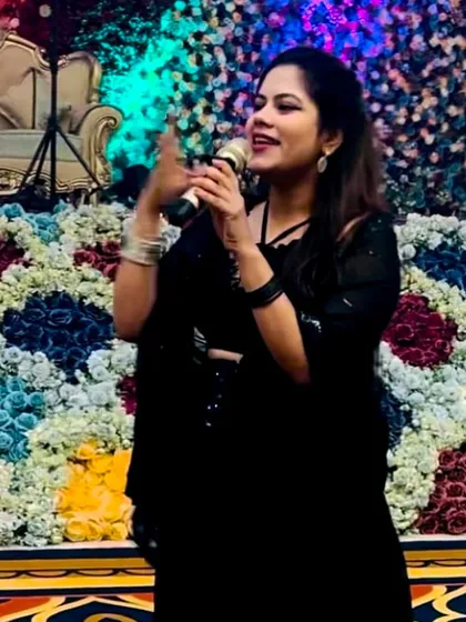 In action with the mic. I love the contrast of the simple black outfit with the vibrant background.