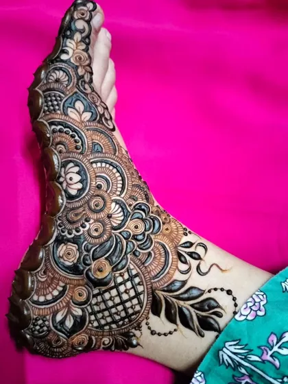 A stunning and intricate foot design that combines floral, paisley, and geometric elements with bold, dark shading for a truly unique look.
