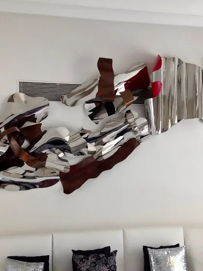 A throwback to a large, 12-foot installation from 2017. This piece combines polished steel with wood-textured and red elements for a complex, abstract composition.