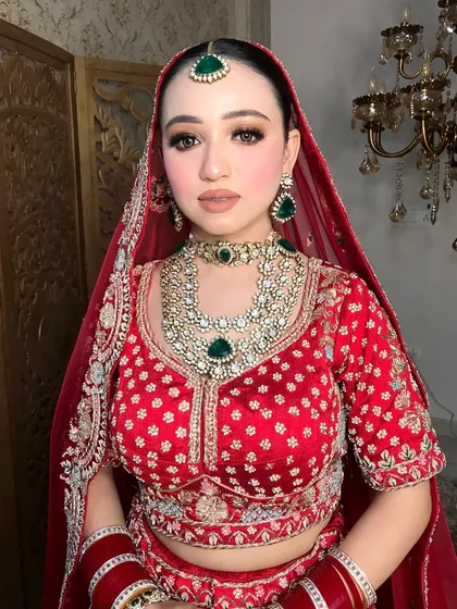 A classic bridal pose, with the red chooda and the heavy jewelry creating a timeless look.