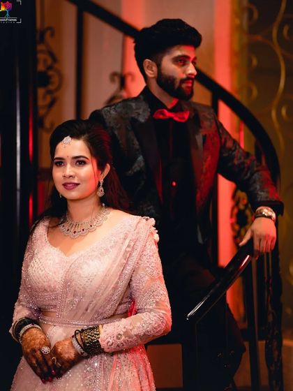 A powerful and stylish portrait of the couple on a staircase. The red lighting and their formal wear create a bold and cinematic image.