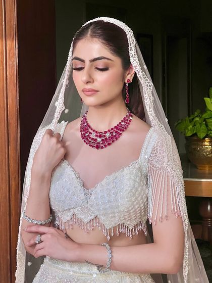 The addition of a delicate veil completes this ethereal bridal look. The makeup is kept soft and romantic, with a focus on glowing skin and gentle contouring.