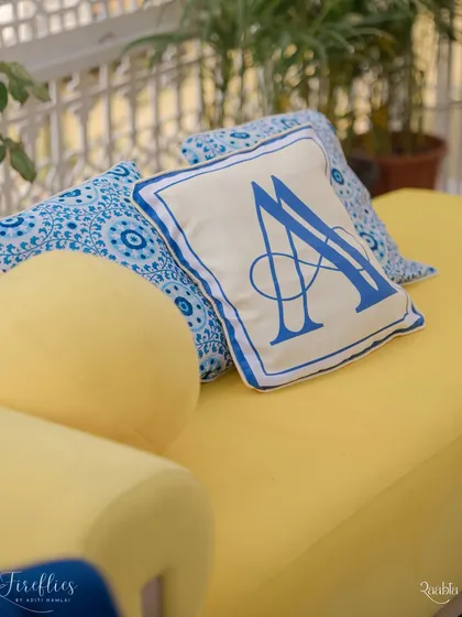 A custom-embroidered cushion with the couple's monogram, designed in the blue-and-white theme of the Jodhpur-inspired Haldi.