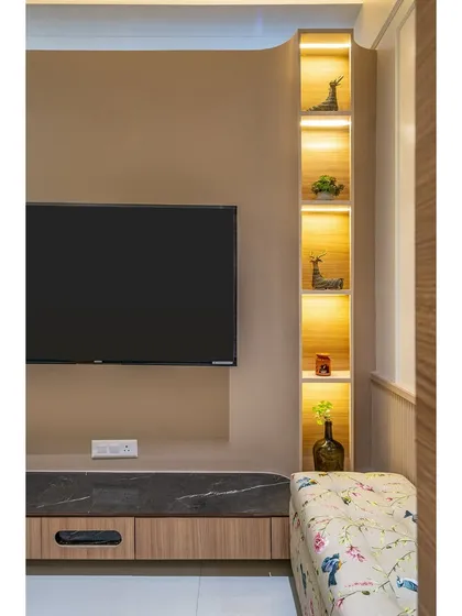 A close-up of a TV unit with integrated, backlit shelving for displaying decor. This design combines media storage with aesthetic appeal.
