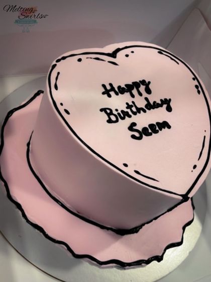 A heart-shaped comic cake in a lovely shade of pink. This whipped cream frosted cake was customized to look like a cartoon drawing, a fun and trendy design.