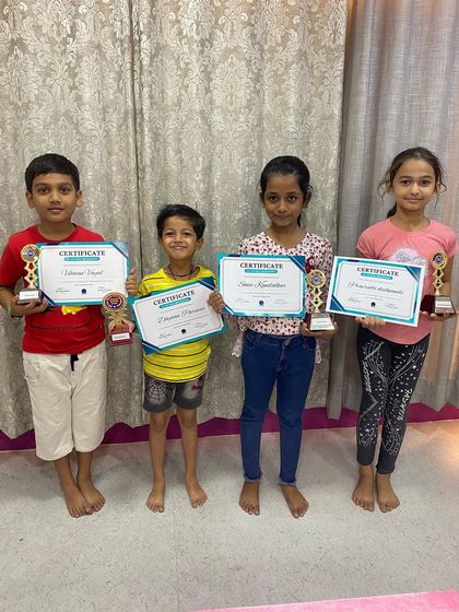 A group of our proud abacus graduates from the Charni Road branch. Each student holds a certificate and trophy, marking their successful completion of the program level.
