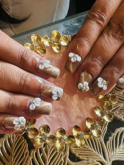 Square-shaped extensions with a shimmering bronze base, decorated with beautiful 3D white flowers and tiny crystal centers.