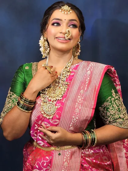 A full view of the bride, showcasing the beautiful saree, heavy temple jewelry, and the complementary makeup.