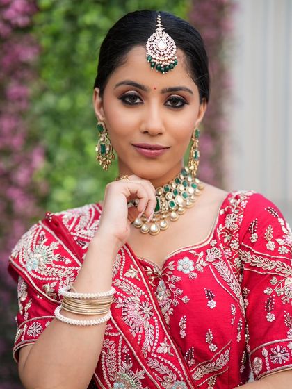 A complete bridal look featuring a heavy, gold-plated Kundan necklace, haath phool, and maang tikka, all available for rent.