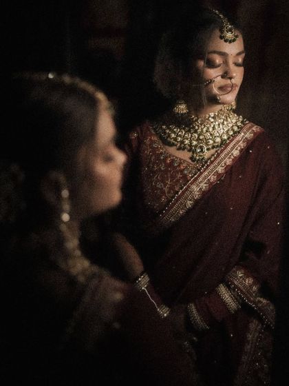 An artistic portrait of a bride with her reflection, creating a layered and introspective image.