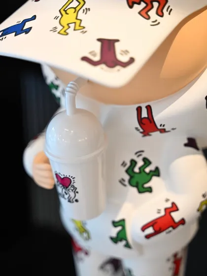 A detail of the cup held by the "Kid Cup" figure, featuring a small heart motif, another nod to Keith Haring's work.