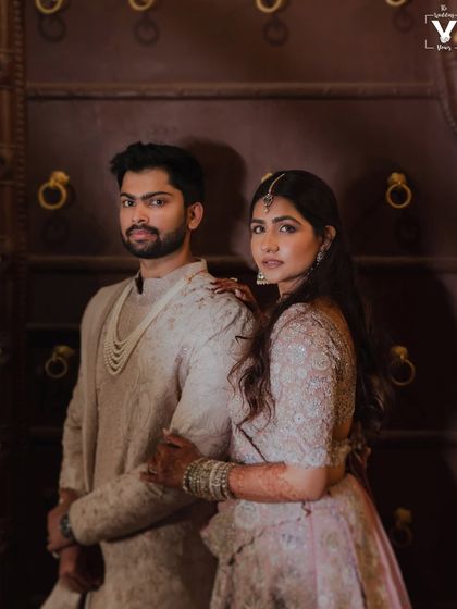 A powerful and elegant portrait of the couple against a grand, traditional door. Their confident poses and coordinated outfits create a regal and timeless image.