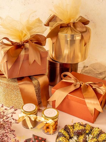 This photo focuses on the luxurious packaging of Diwali gift hampers. The rich colors, satin ribbons, and elegant boxes create a premium feel, appealing to customers looking for high end festive gifts.