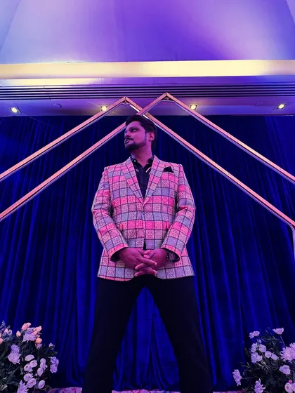 A powerful low-angle shot showcasing my stage-ready attire. A confident stance and a sharp outfit are part of my professional toolkit.