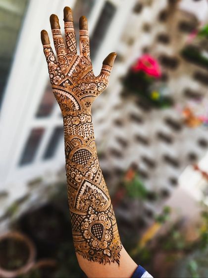 The back of the hand, showcasing the detailed finger work and the continuation of the V-shaped arm pattern.