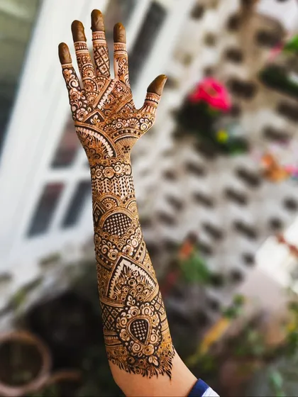 The back of the hand, showcasing the detailed finger work and the continuation of the V-shaped arm pattern.