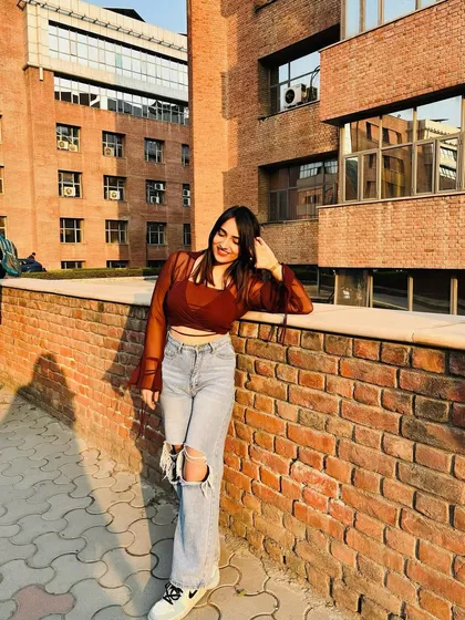 A relaxed pose against a brick wall. The urban background perfectly complements the street style look.