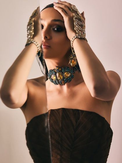 A creative shot for Reasons Jewellery using a mirror to create a reflection, focusing on the intricate design of the choker and hand harnesses.