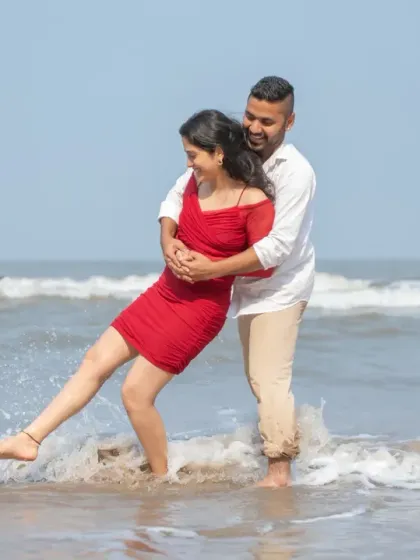 Splashing in the waves together. This playful and candid moment captures the fun-loving spirit of the couple during their beach pre-wedding shoot.