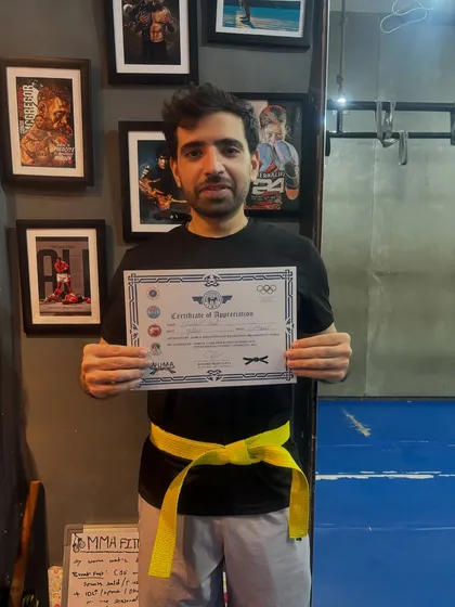 The journey begins with the first step. Here is one of my students proudly showing his Level One certificate and new yellow belt in kickboxing.