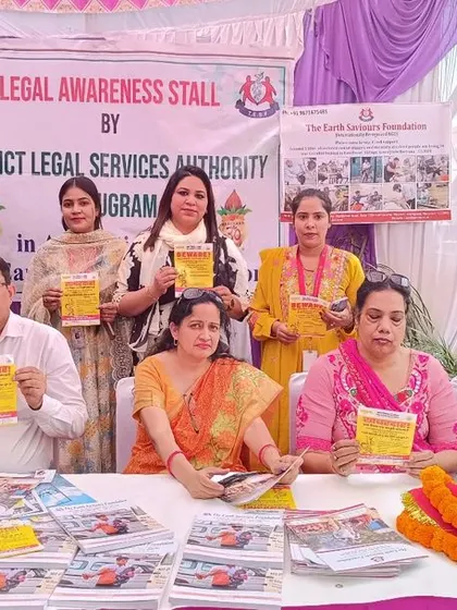 Our team holding up informational pamphlets at the DLSA legal aid camp. Spreading awareness is a crucial part of our mission to empower the community with legal knowledge.