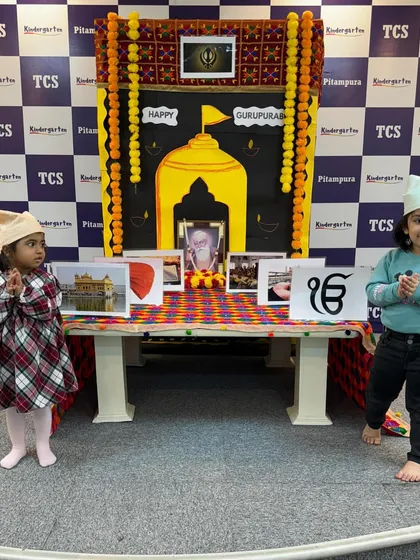 Two girls in front of the Gurpurab display. Our celebrations are designed to be inclusive and educational for all children.