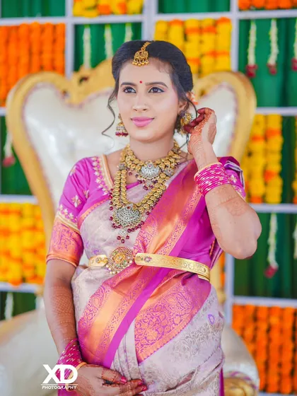 A detailed shot of the mother-to-be, highlighting her intricate jewelry and the beautiful fabric of her saree during the baby shower ceremony.