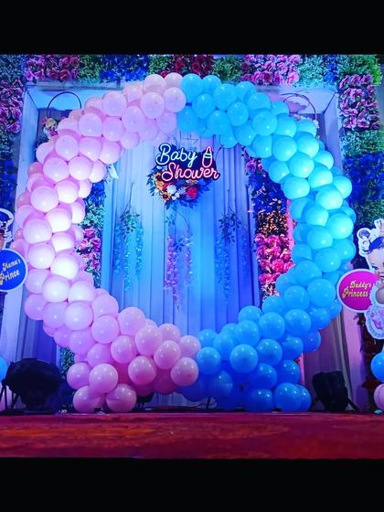 A gender-reveal baby shower theme with a circular balloon arch in pink and blue. The 'Baby's Prince' and 'Daddy's Princess' cutouts add a cute, personal touch.