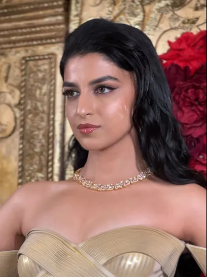 A glamorous Sangeet look with wet-look waves, giving a modern and edgy vibe to this stunning golden gown.