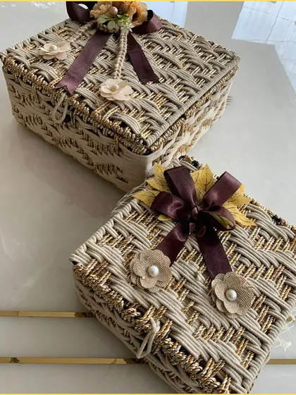 The stunning beige and gold jute hamper, closed to showcase the beautiful ribbon and floral embellishments. It's a testament to eco-friendly luxury.