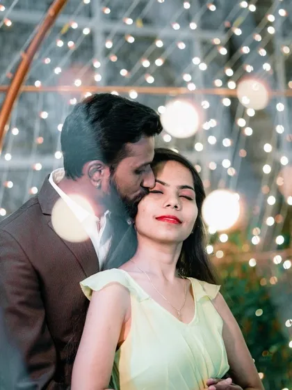 An artistic and romantic portrait with light flares, capturing a tender moment between the couple.