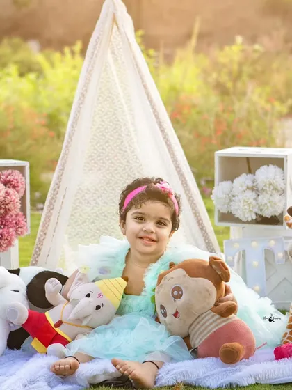 A happy smile from the birthday girl, surrounded by her toys in our lovely outdoor teepee setup. A perfect portrait for a second birthday.