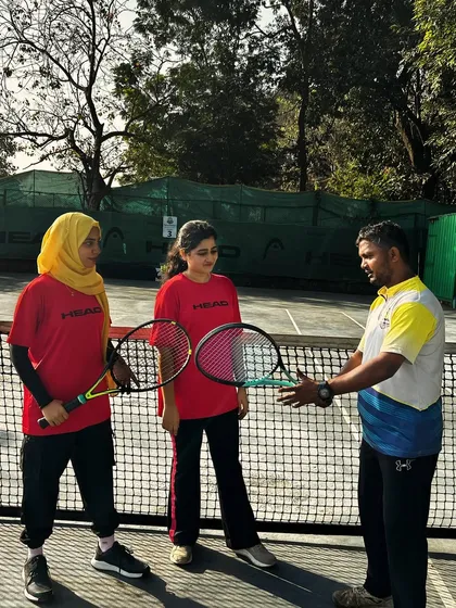 A coach provides instruction to two players, demonstrating our commitment to personalized guidance and technique refinement.
