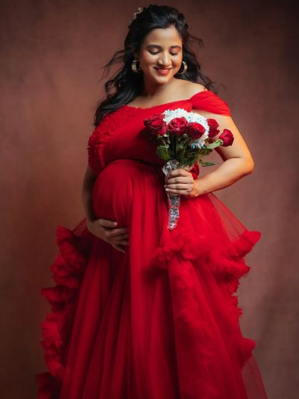 Feel powerful and gentle in this red off-shoulder ruffle gown. It's designed to make you feel confident and beautiful during your maternity shoot.