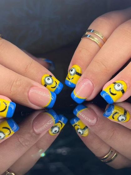 A fun and playful manicure featuring hand-painted Minions on a French tip base.