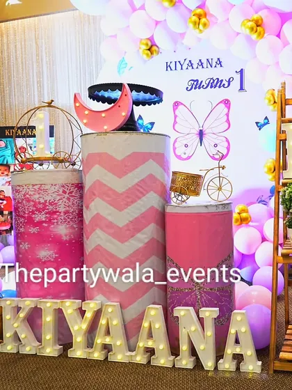 A detail shot of the custom pedestals and light-up name for a butterfly-themed party. The chevron and floral patterns add a unique touch.