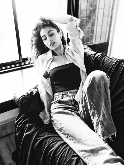 A relaxed, black and white portrait from a home shoot. The natural window light gives it a soft, documentary feel.