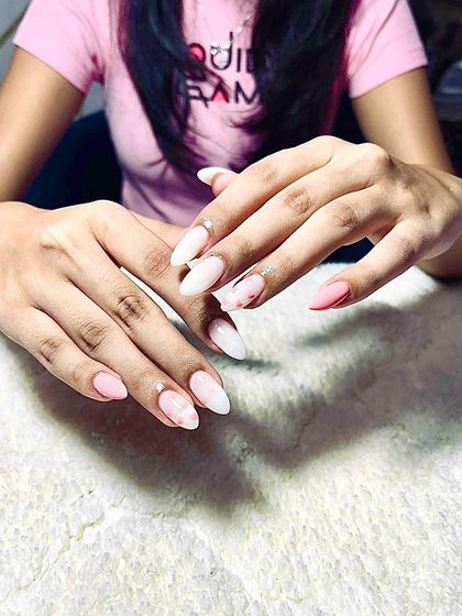 A beautiful marble design in shades of pink and white on almond-shaped extensions.