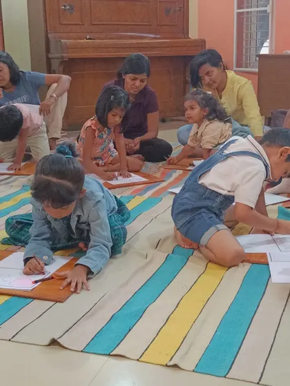 Children are engrossed in coloring their monkey-themed worksheets, a quiet and focused activity after an energetic story.