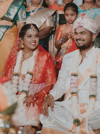 The bride and groom seated together during their ceremony, their faces lit with happiness.