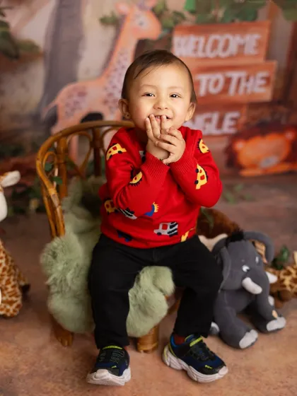 A sweet and shy smile from this little boy in his jungle themed sitter session. He is surrounded by his favorite stuffed animals.