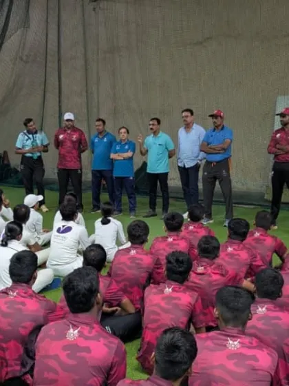 Another view of the coaching session, with players seated and focused on the instructions for the upcoming drills.