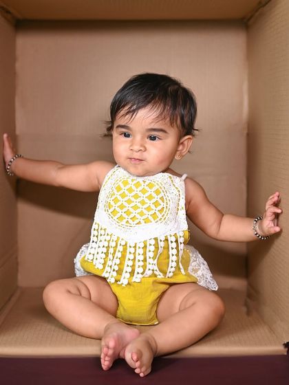 This baby is stretching out and making themselves comfortable in their cardboard box fort.