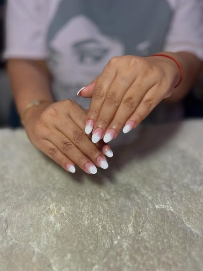 A classic baby boomer or ombre nail design on short, almond-shaped extensions for a clean and natural-looking manicure.