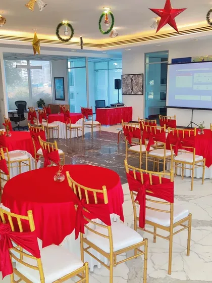 We transform indoor spaces for corporate functions, like this Christmas event at the BPTP Amstoria sales office. The setup includes festive red-themed table arrangements, formal seating, and a projector screen, making the space suitable for both celebration and presentations.