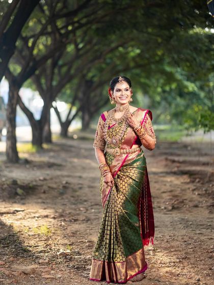 An outdoor shot showcasing a beautiful engagement saree. The drape is done to allow easy movement while ensuring the rich fabric and border are displayed beautifully.