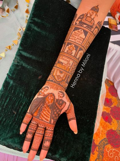 This custom design includes a portrait of the bride with her family, capturing a precious memory in henna.