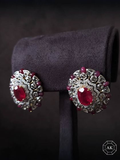 A touch of royalty for any occasion. These oval-shaped earrings feature large natural African rubies surrounded by ruby beads, rose-cut, and round diamonds.