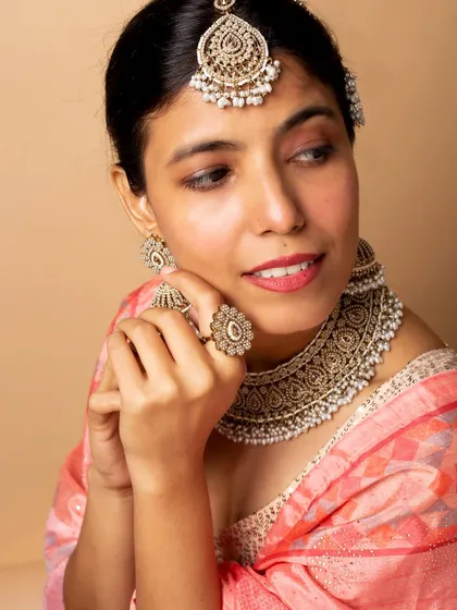 A portrait that captures the beauty of a traditional jewelry set in a candid-style pose. This helps customers visualize themselves wearing the pieces for a special occasion.