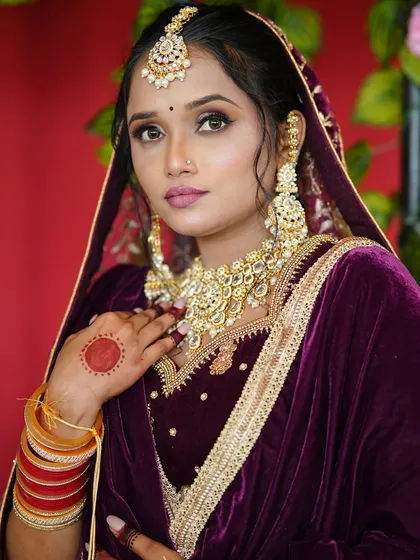 This bride's look is all about grace. The soft makeup with a defined eye and a subtle lip color enhances her features while complementing her traditional Punjabi bridal attire.